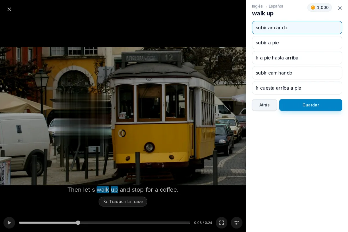 Un video en pausa con una línea de subtítulos, dos de sus palabras elegidas como frase y sus traducciones abiertas debajo