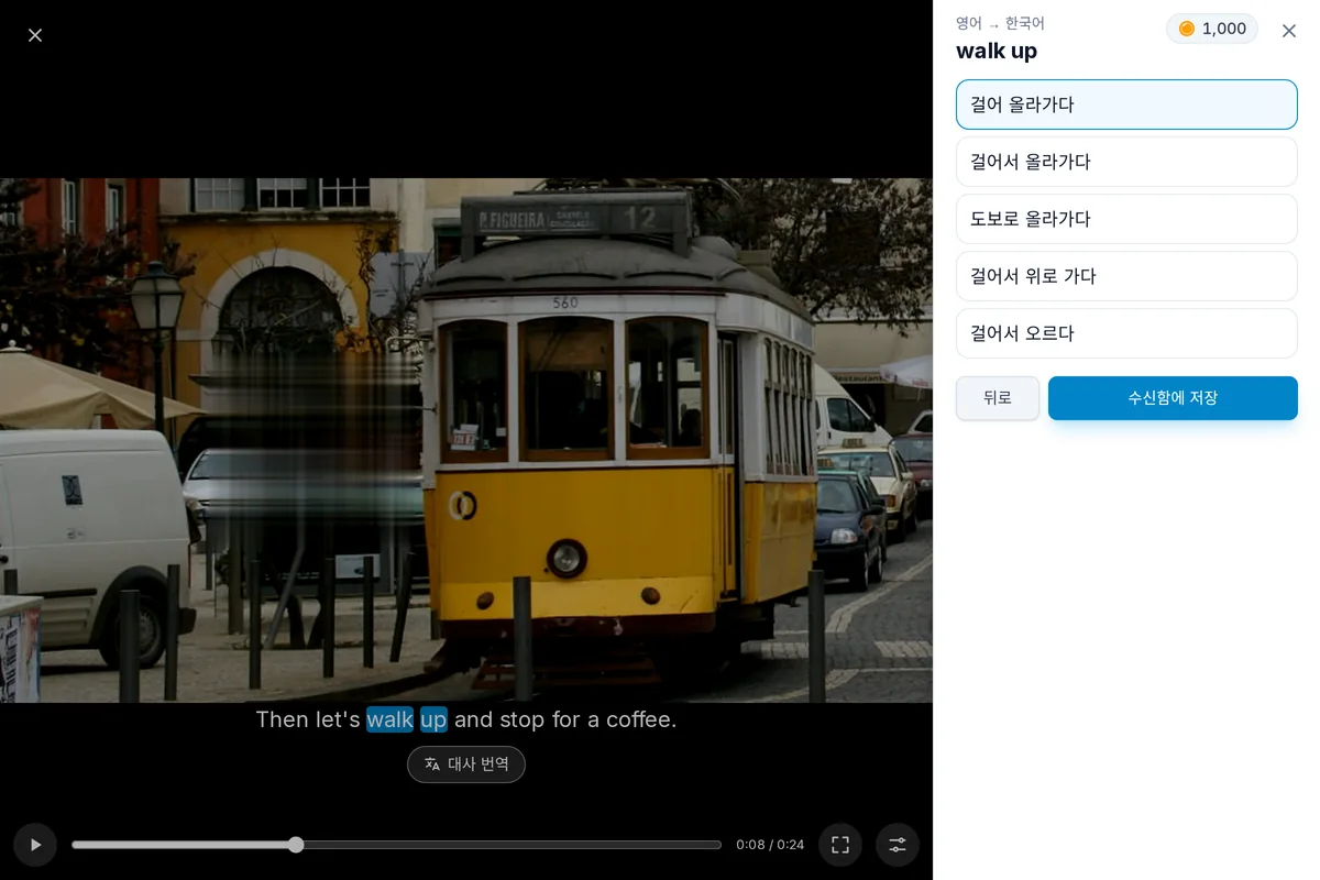 자막 한 줄이 보이는 멈춘 동영상. 두 단어가 표현으로 선택되어 있고, 그 아래에 번역이 열린 모습