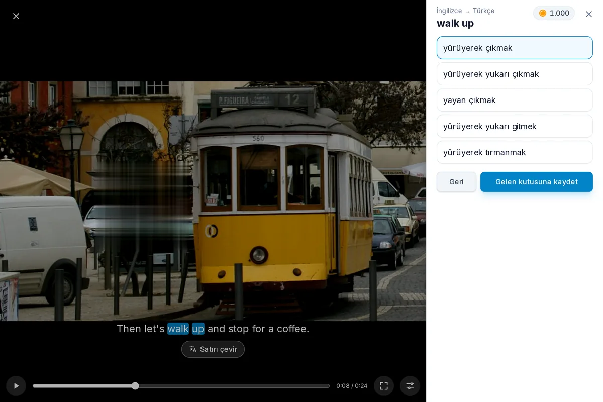 Duraklatılmış bir video ve altyazı satırı: iki kelimesi ifade olarak seçilmiş, çevirileri altta açık
